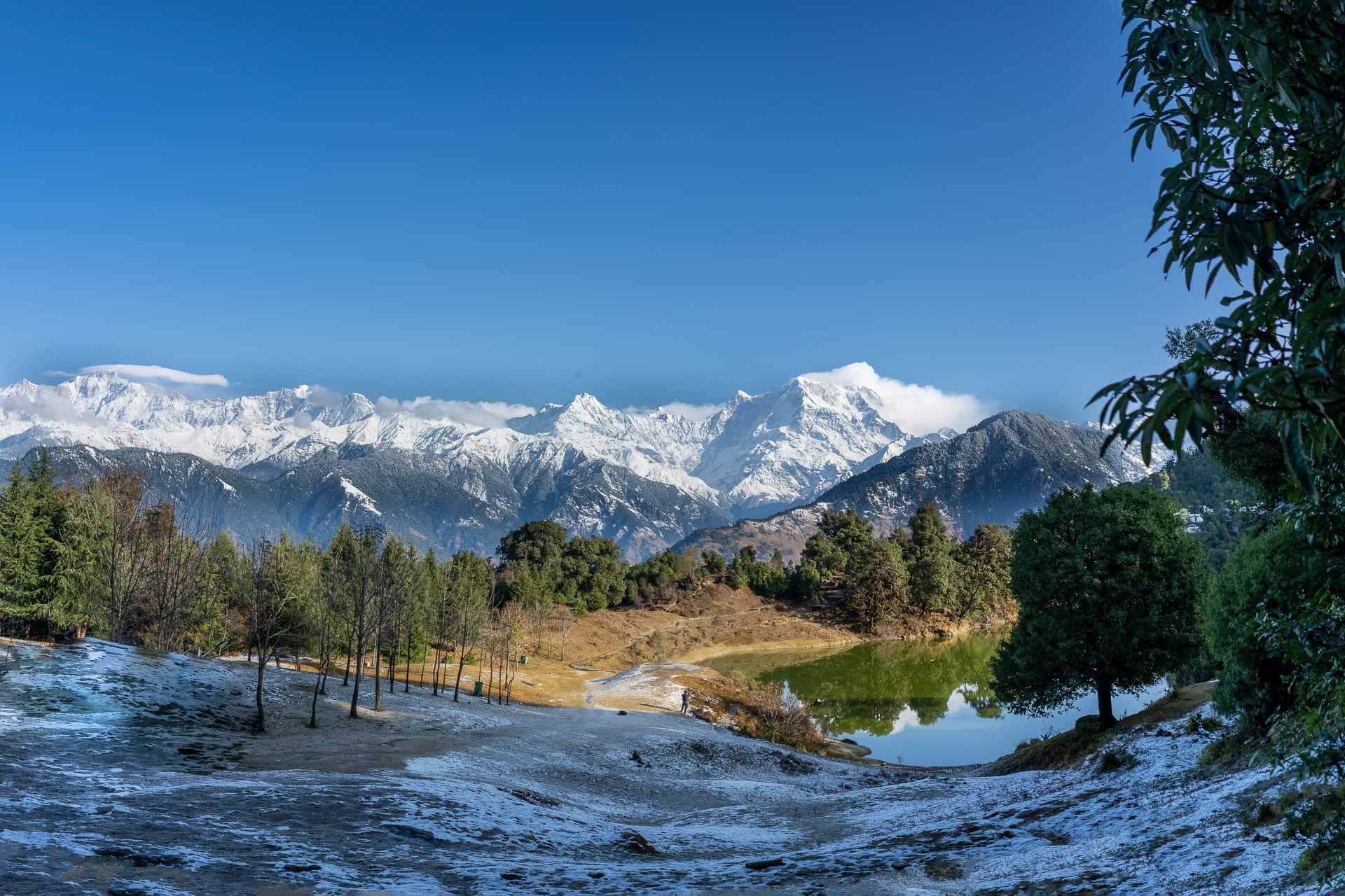 Teh Devariya Tal lake shot from an angle showing mountain tips in the background