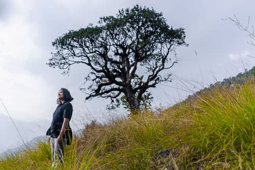 A lady standing next to a tree