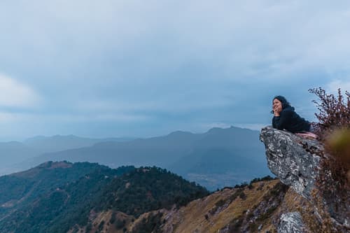 A person hanging from a natural ledge