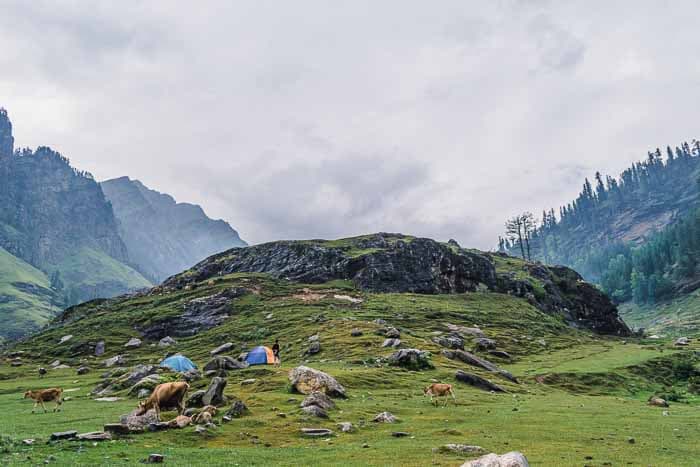 Rocky mountains with tents in the distance