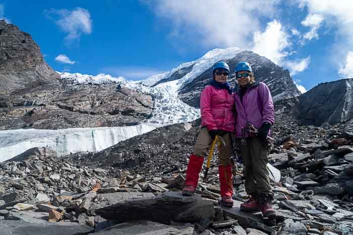 Two mountain climber standing at the foot of a peak