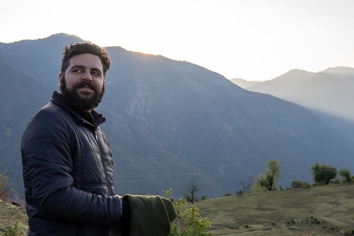 Aditya in front of a mountainous backdrop